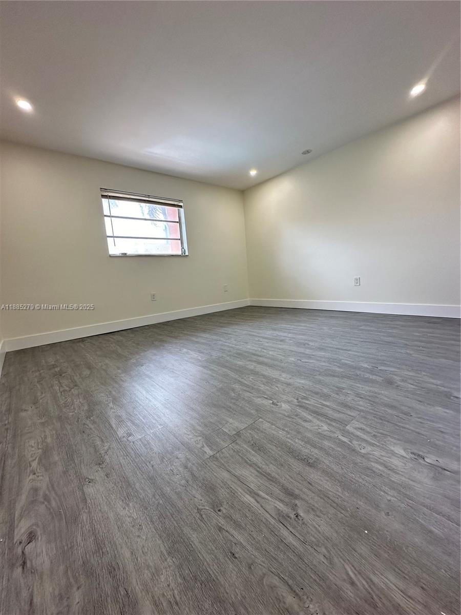 1555 West 44th Place, Unit 234 Hialeah, FL 33012 - Photo 23 of 36 an empty room with wooden floor and windows