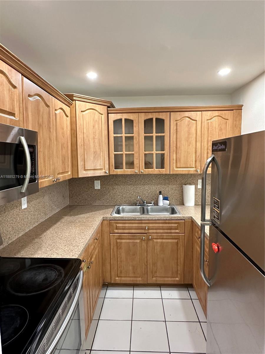 1555 West 44th Place, Unit 234 Hialeah, FL 33012 - Photo 8 of 36 a kitchen with stainless steel appliances a stove a sink and a refrigerator