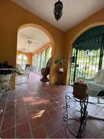 a living room with a floor to ceiling window and furniture