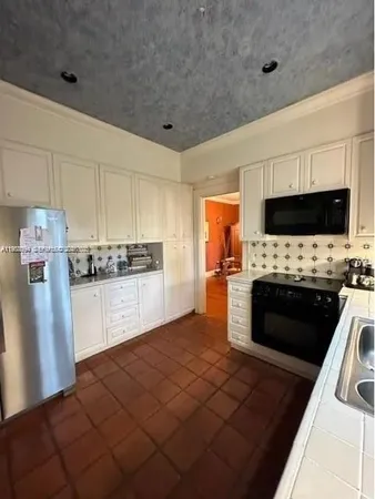 a kitchen with granite countertop a refrigerator stove and microwave