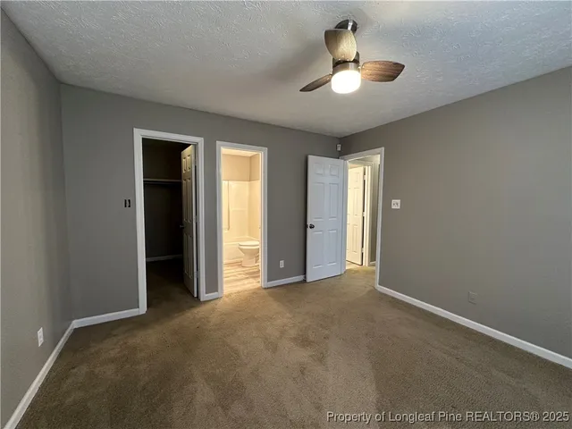 an empty room with ceiling fan and window