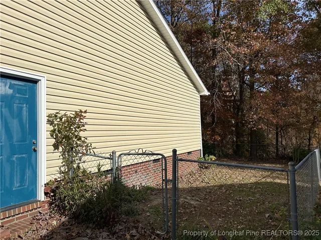 a view of a house with backyard and trees