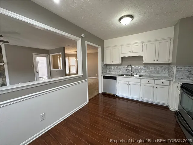 a kitchen with cabinets stainless steel appliances a sink and a window