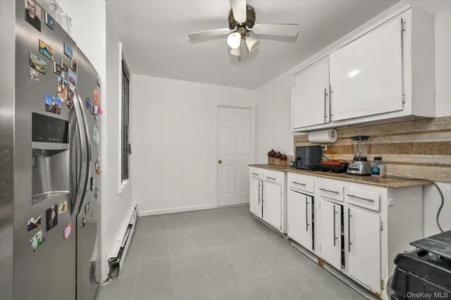 a kitchen with stainless steel appliances granite countertop a refrigerator a sink dishwasher and white cabinets with wooden floor