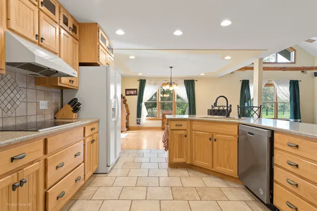 a large kitchen with stainless steel appliances lots of counter space and a sink