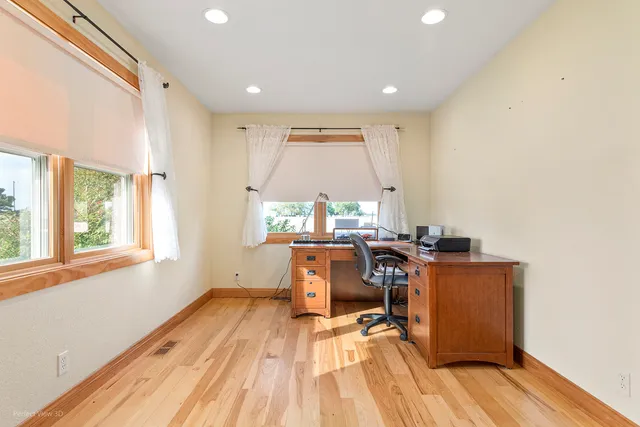 a view of workspace with wooden floor and windows
