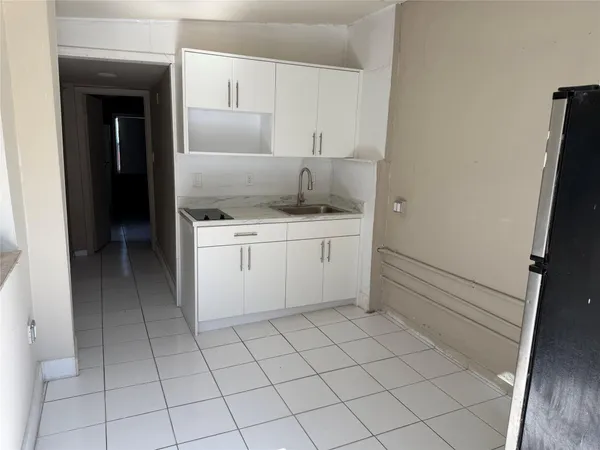 a kitchen with white cabinets a sink and appliances