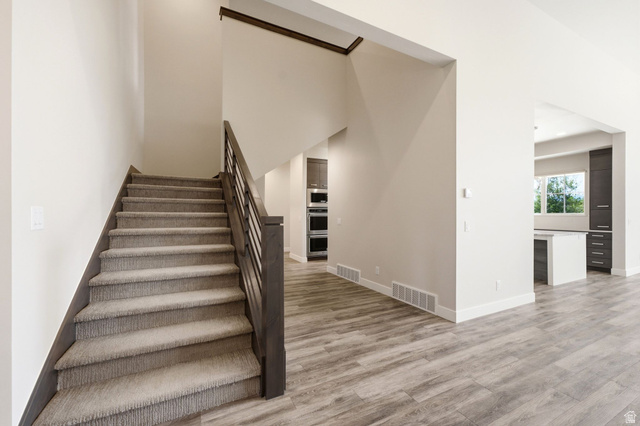 496 North Farmhouse Way, Unit 11 Midway, UT 84049 - Photo 14 of 50 Carpeted staircase with dark wood-finish handrail and black metal balusters