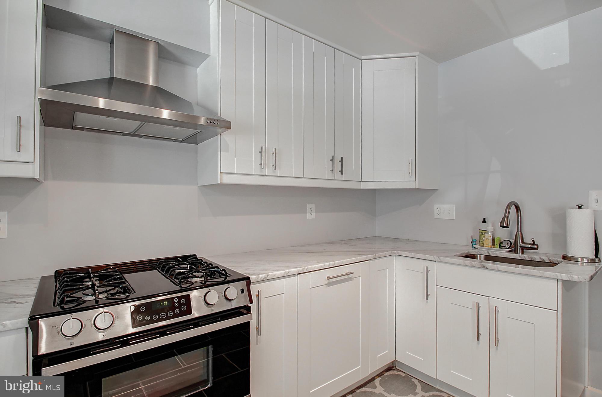 7222 Brookfalls Terrace Baltimore, MD 21209 - Photo 11 of 29 a kitchen with white cabinets and appliances