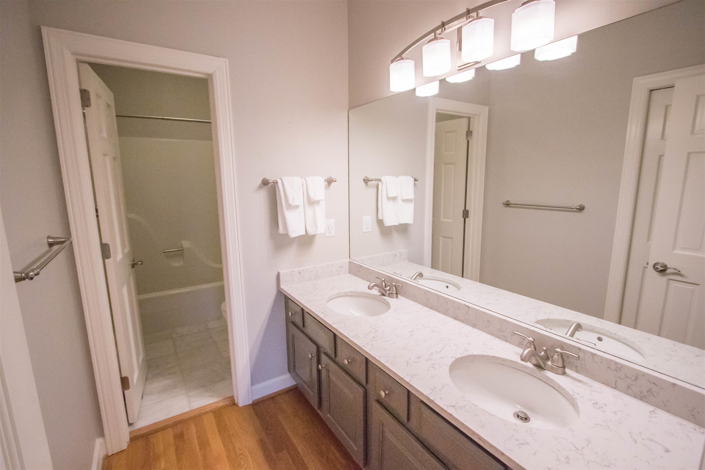 4304 Warren Road Franklin, TN 37067 - Photo 12 of 30 a bathroom with a double vanity sink mirror and shower