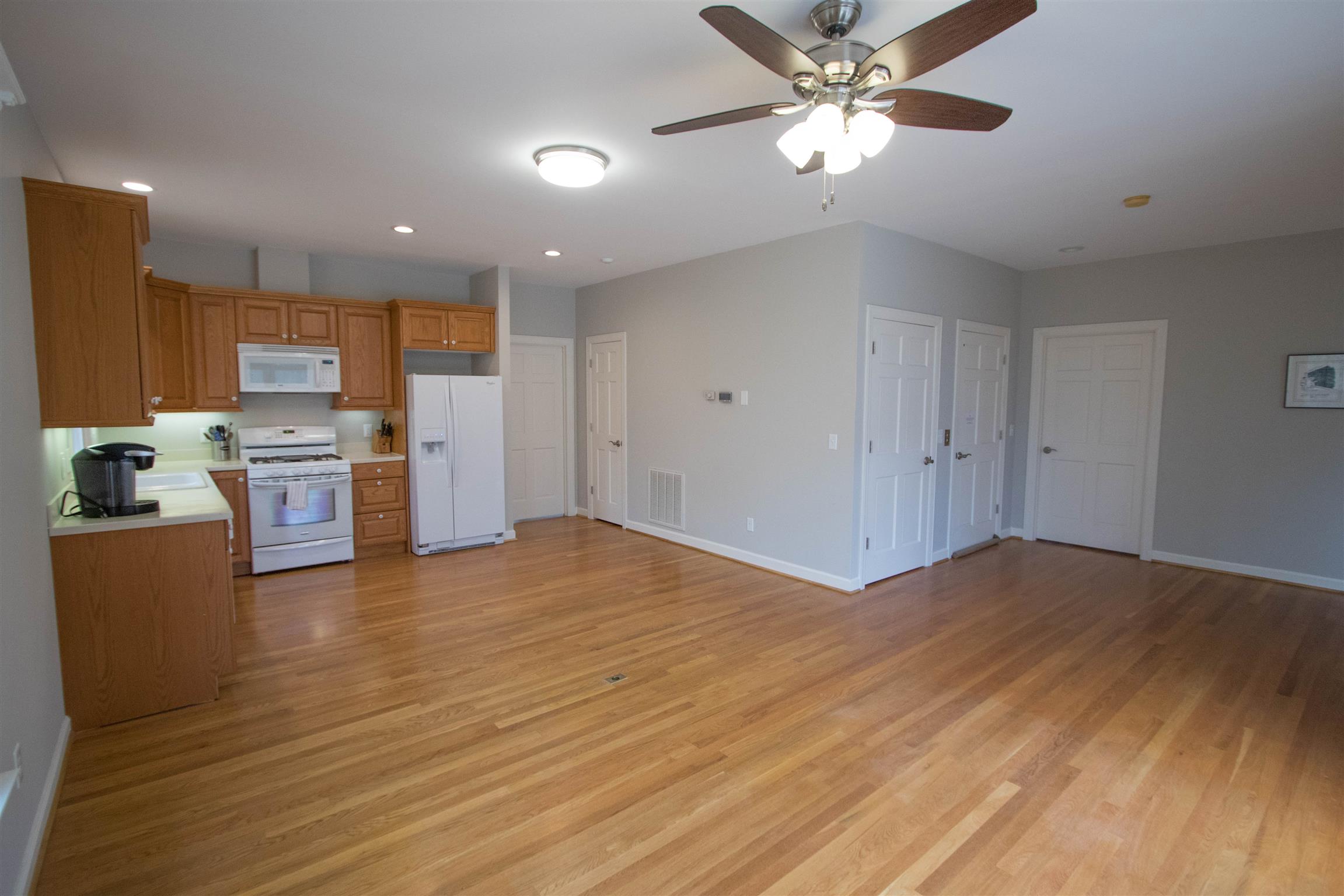 4304 Warren Road Franklin, TN 37067 - Photo 16 of 30 a view of a kitchen with a stove cabinets wooden floor and a ceiling fan