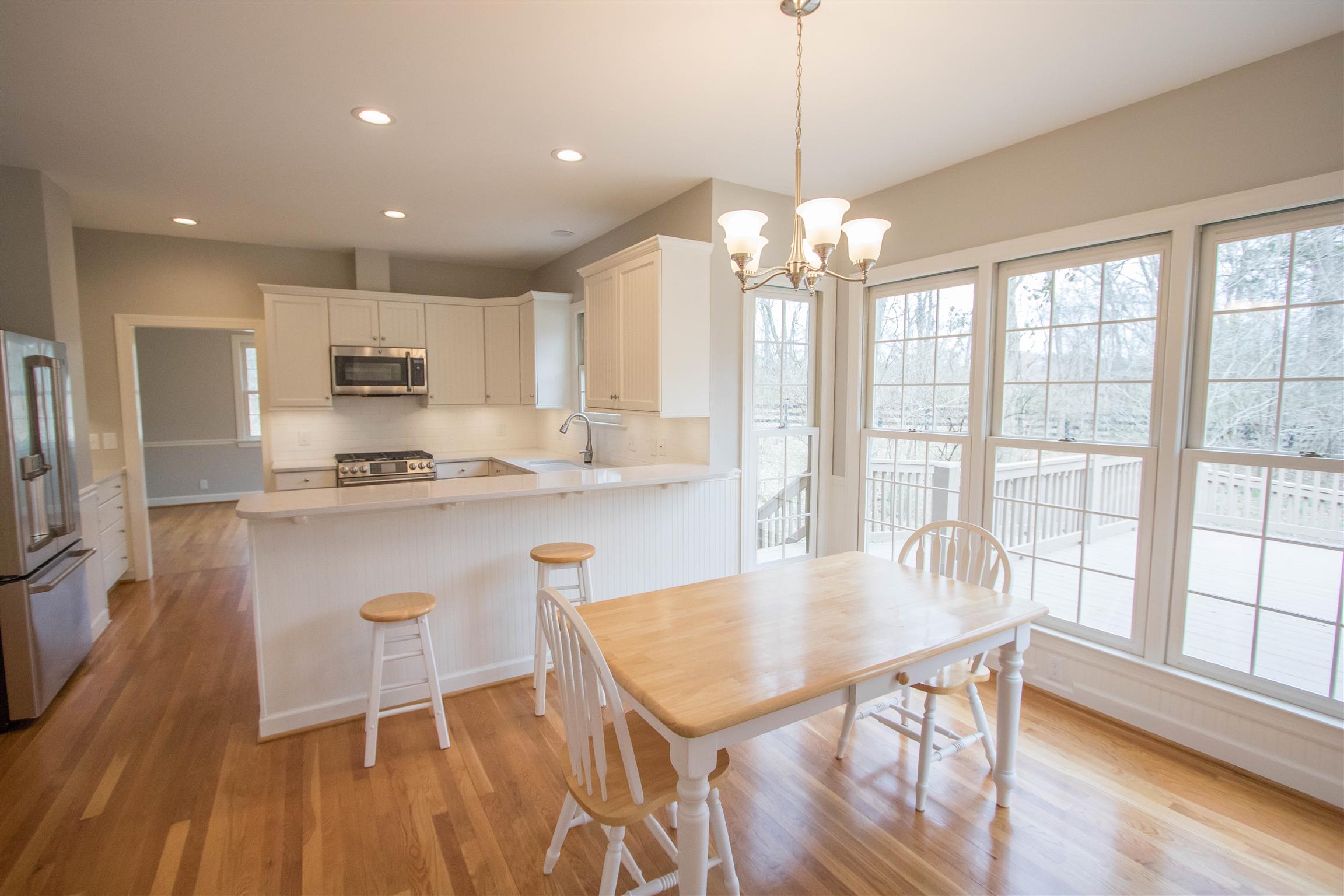 4304 Warren Road Franklin, TN 37067 - Photo 9 of 30 a kitchen with kitchen island granite countertop a stove a refrigerator a dining table and chairs with wooden floor