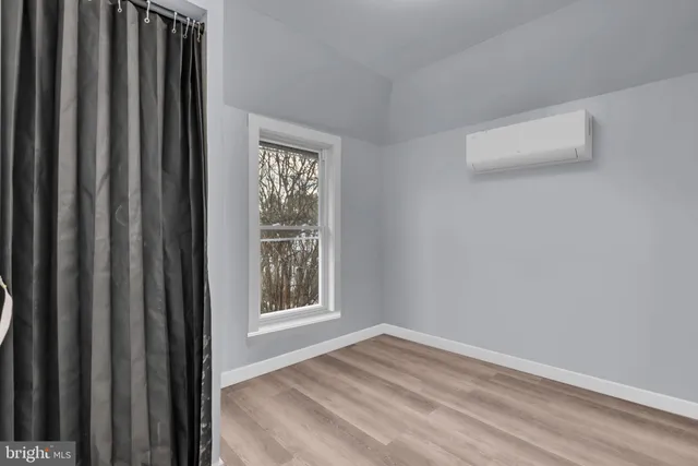 a view of a livingroom with wooden floor and a window