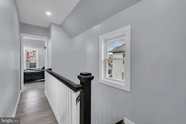 a view of a hallway view with wooden floor and a bathroom