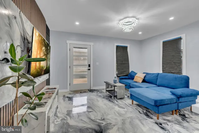 a living room with furniture a flat screen tv and a window