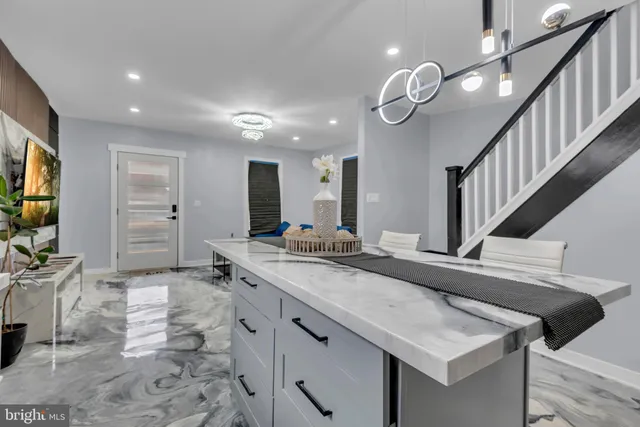 a kitchen with stainless steel appliances granite countertop a sink a stove top oven a chimney and a refrigerator