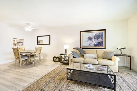 a living room with furniture two night stand and a potted plant
