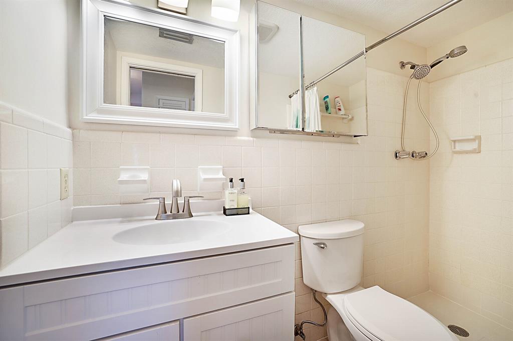 1951 Northeast 39th Street, Unit 343 Lighthouse Point, FL 33064 - Photo 20 of 28 a bathroom with a sink toilet and mirror