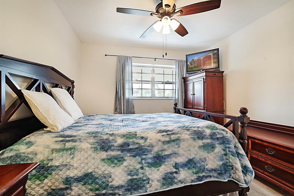 1951 Northeast 39th Street, Unit 343 Lighthouse Point, FL 33064 - Photo 21 of 28 a bedroom with a bed and wooden floor