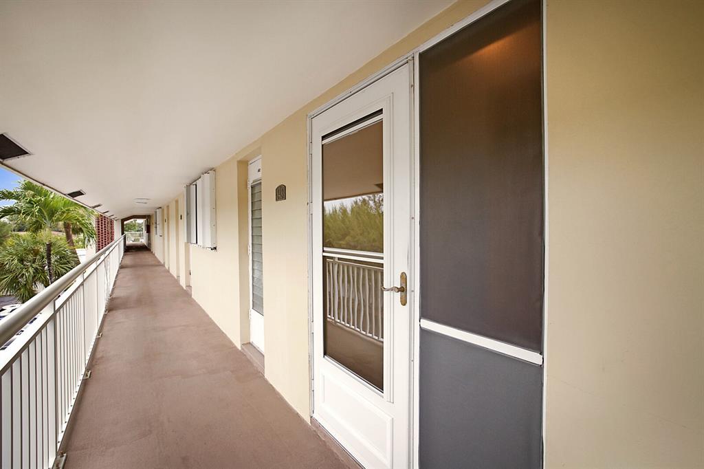 1951 Northeast 39th Street, Unit 343 Lighthouse Point, FL 33064 - Photo 5 of 28 a view of a hallway with wooden floor and windows