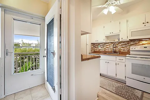a kitchen with white cabinets and window