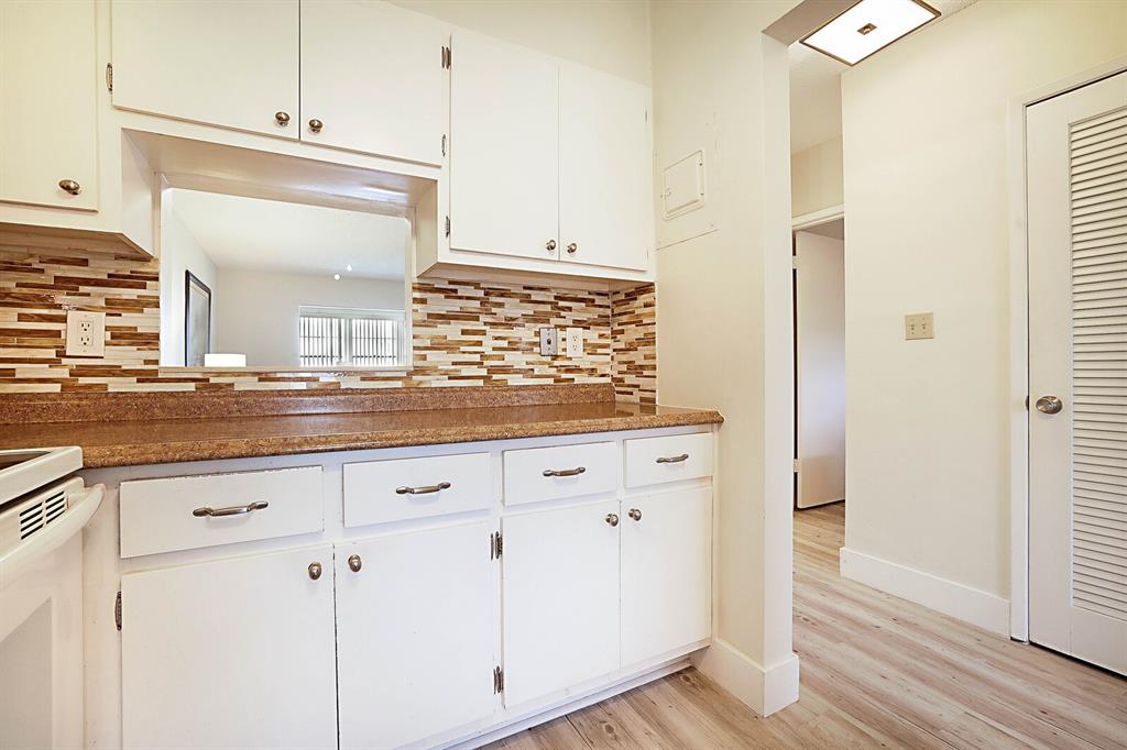 1951 Northeast 39th Street, Unit 343 Lighthouse Point, FL 33064 - Photo 7 of 28 a kitchen with granite countertop white cabinets and white appliances