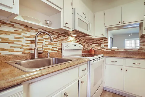 a kitchen with stainless steel appliances granite countertop a sink and cabinets