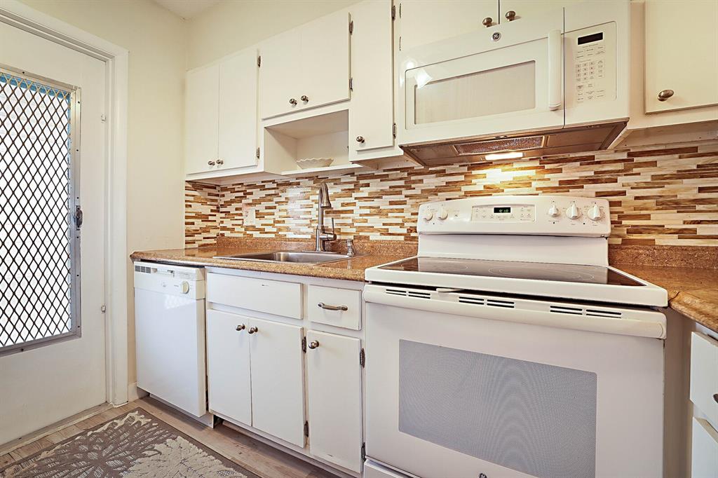 1951 Northeast 39th Street, Unit 343 Lighthouse Point, FL 33064 - Photo 10 of 28 a kitchen with granite countertop a sink cabinets and stainless steel appliances
