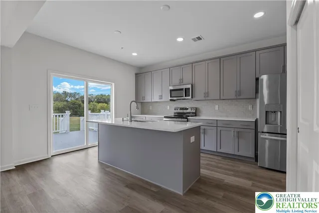a kitchen with a refrigerator stove top oven and sink