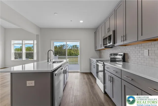 a kitchen with stainless steel appliances granite countertop a sink stove and wooden cabinets