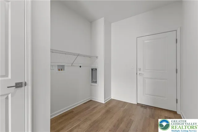 a view of an empty room with wooden floor and closet