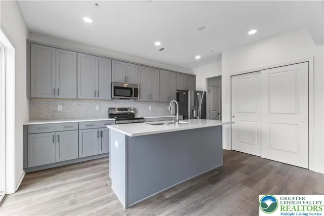 a kitchen with stainless steel appliances granite countertop a refrigerator and a stove top oven