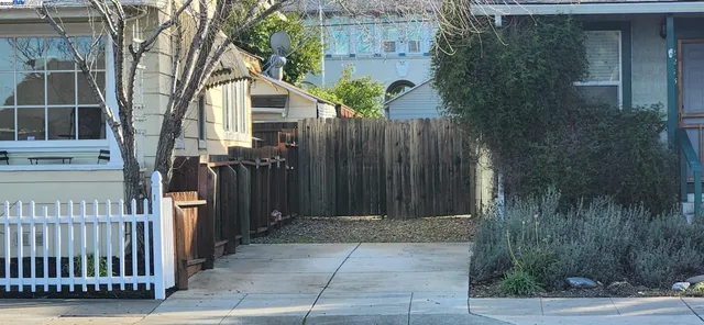 a view of a house with a wooden fence