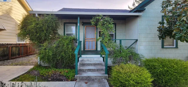 a front view of a house with plants