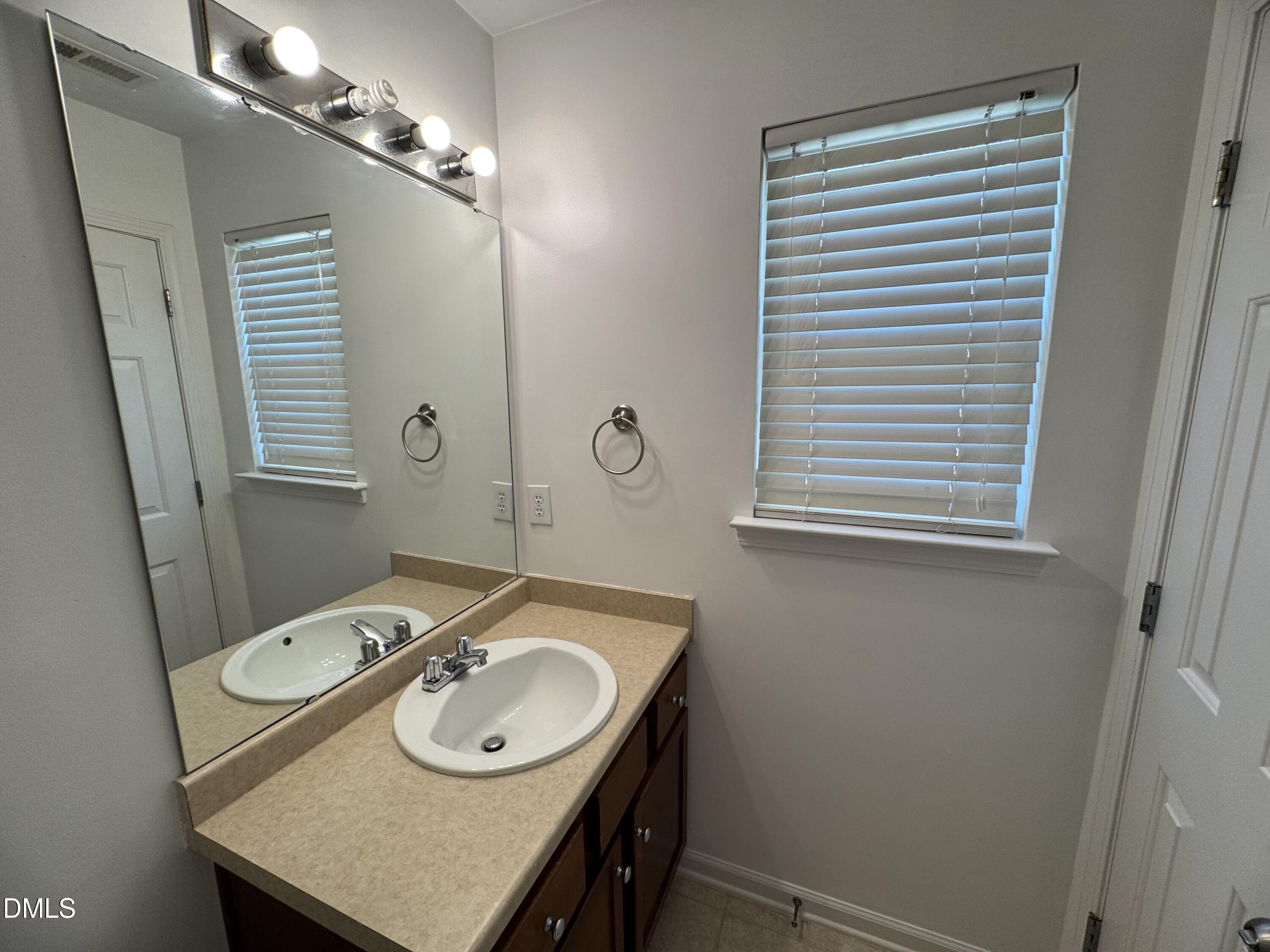 2212 Persimmon Ridge Drive Raleigh, NC 27604 - Photo 11 of 20 a bathroom with a sink a vanity and a mirror