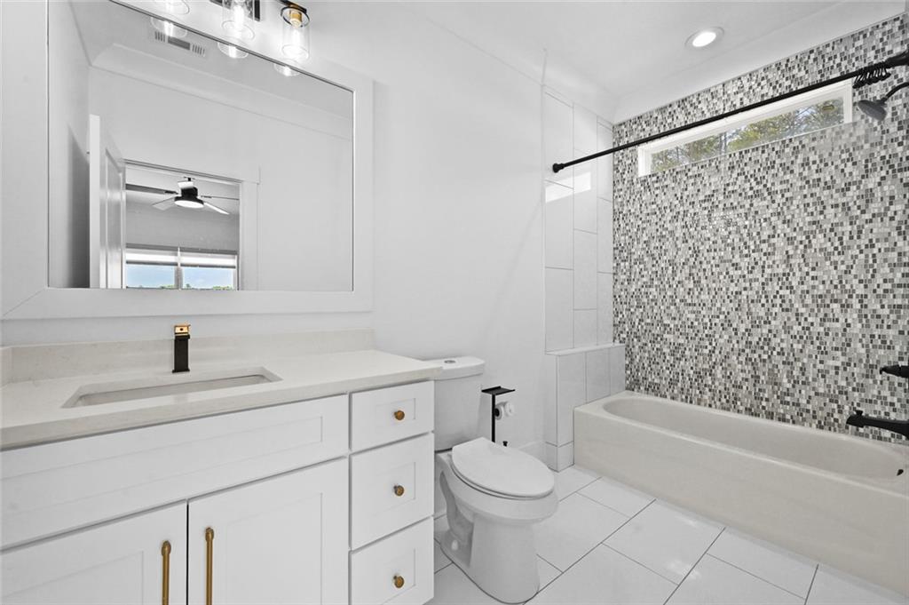 2694 Thompson Mill Road Buford, GA 30519 - Photo 48 of 70 a bathroom with a sink toilet a mirror and shower