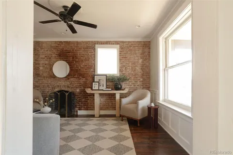 a living room with furniture a fireplace and a large window
