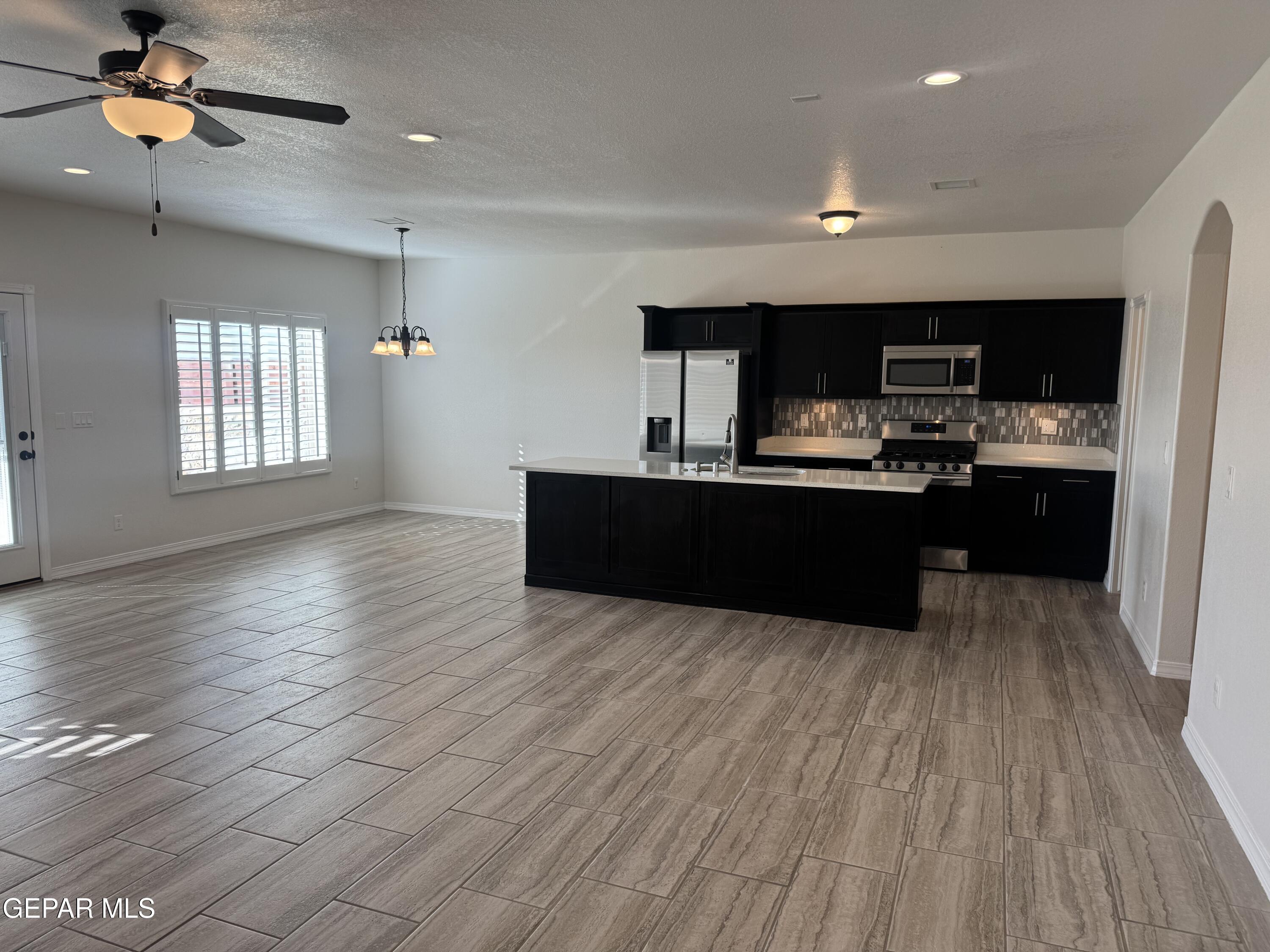 412 Indigo Court El Paso, TX 79932 - Photo 12 of 53 a kitchen with stainless steel appliances granite countertop a sink cabinets and wooden floor