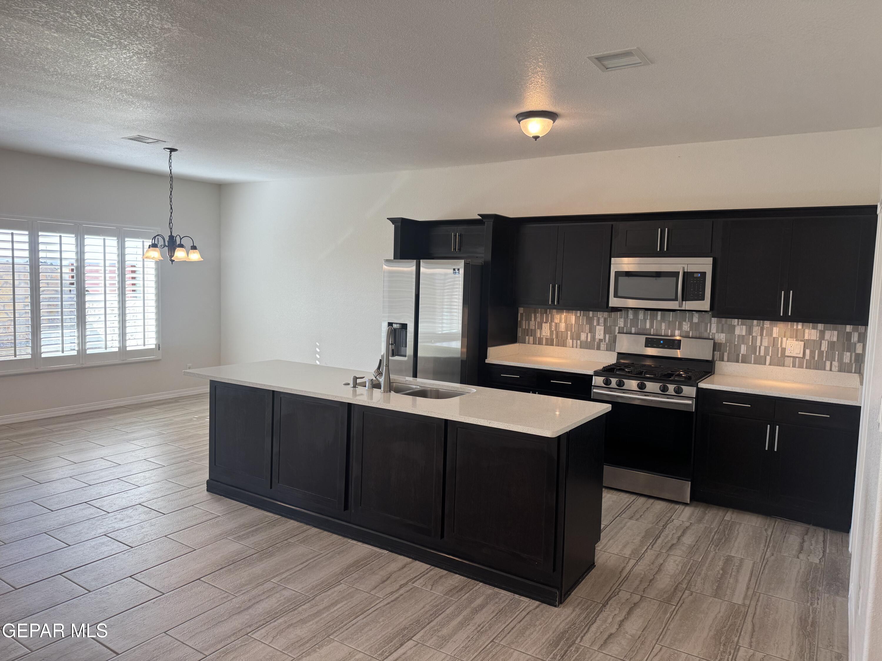 412 Indigo Court El Paso, TX 79932 - Photo 14 of 53 a kitchen with stainless steel appliances granite countertop a sink and a stove