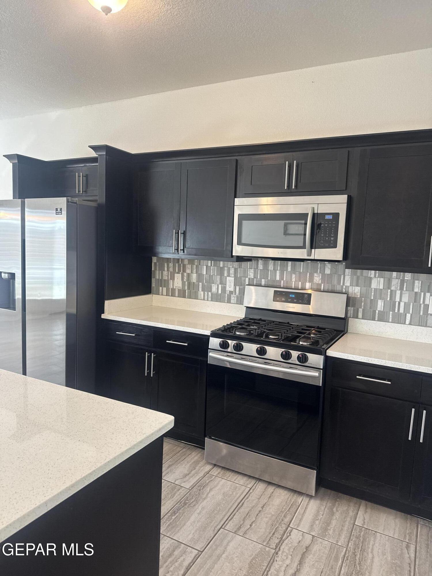 412 Indigo Court El Paso, TX 79932 - Photo 16 of 53 a kitchen with a stove and a refrigerator