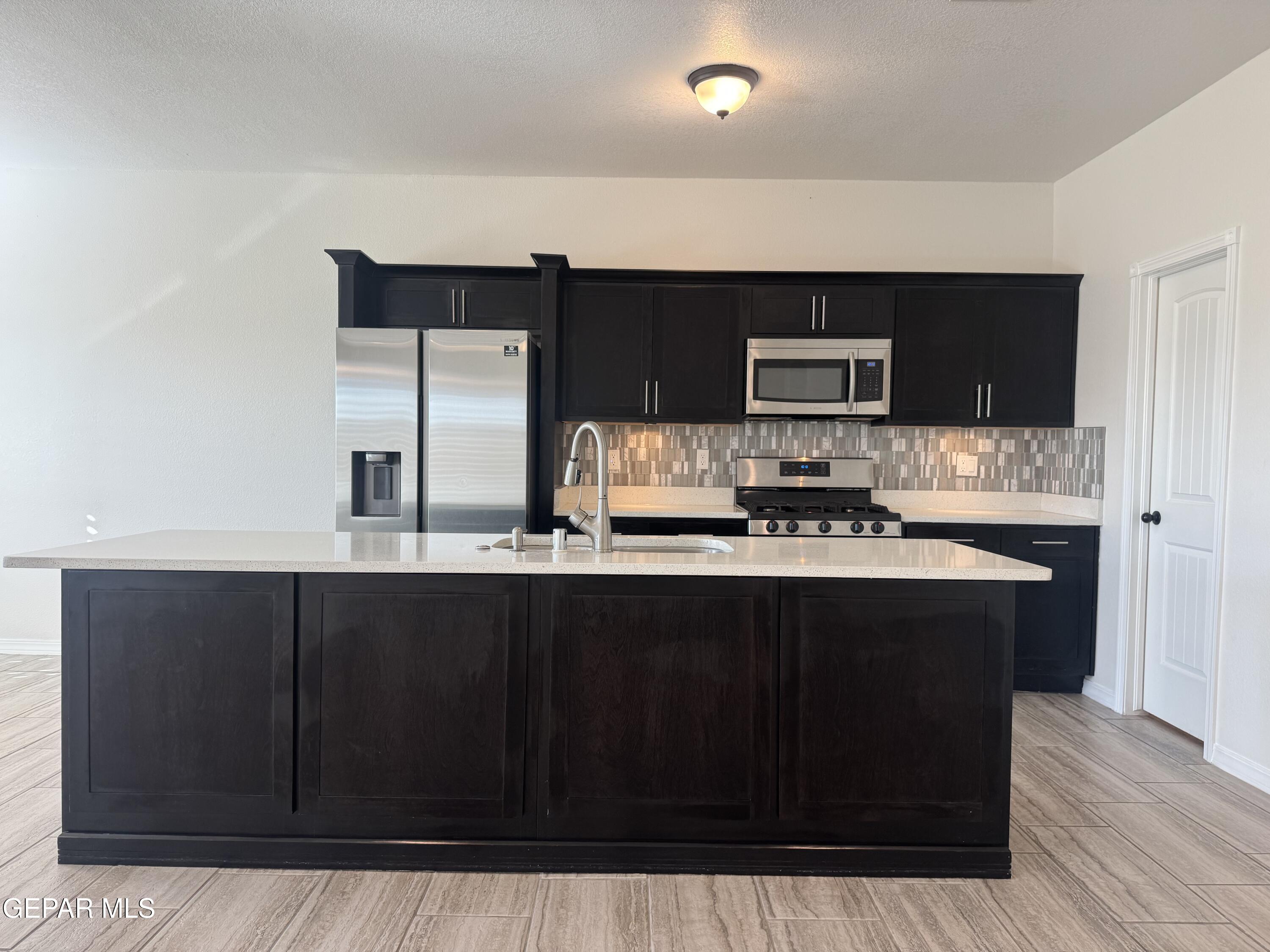 412 Indigo Court El Paso, TX 79932 - Photo 19 of 53 a kitchen with stainless steel appliances wooden cabinets and a sink