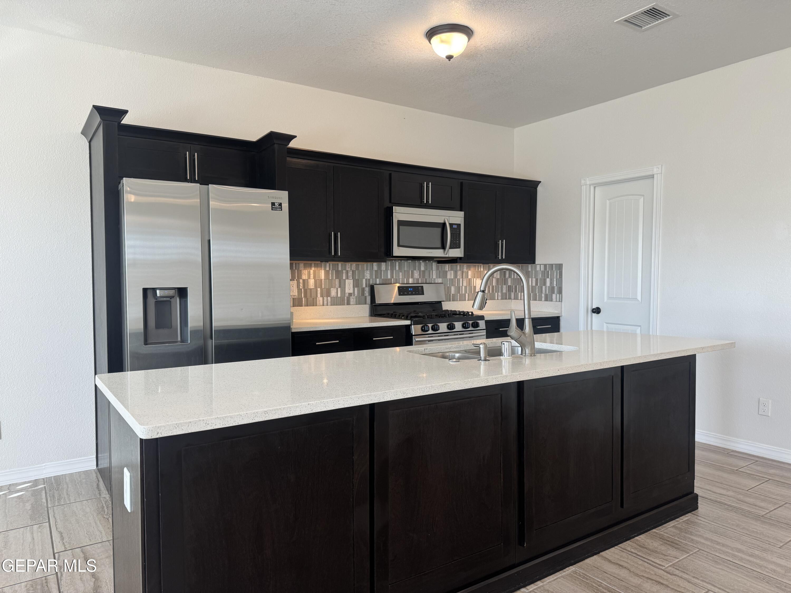 412 Indigo Court El Paso, TX 79932 - Photo 20 of 53 a kitchen with stainless steel appliances a sink cabinets and wooden floor