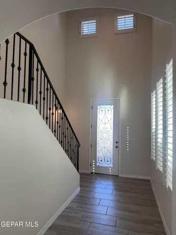 a view of staircase with lots of frames on wall and a window