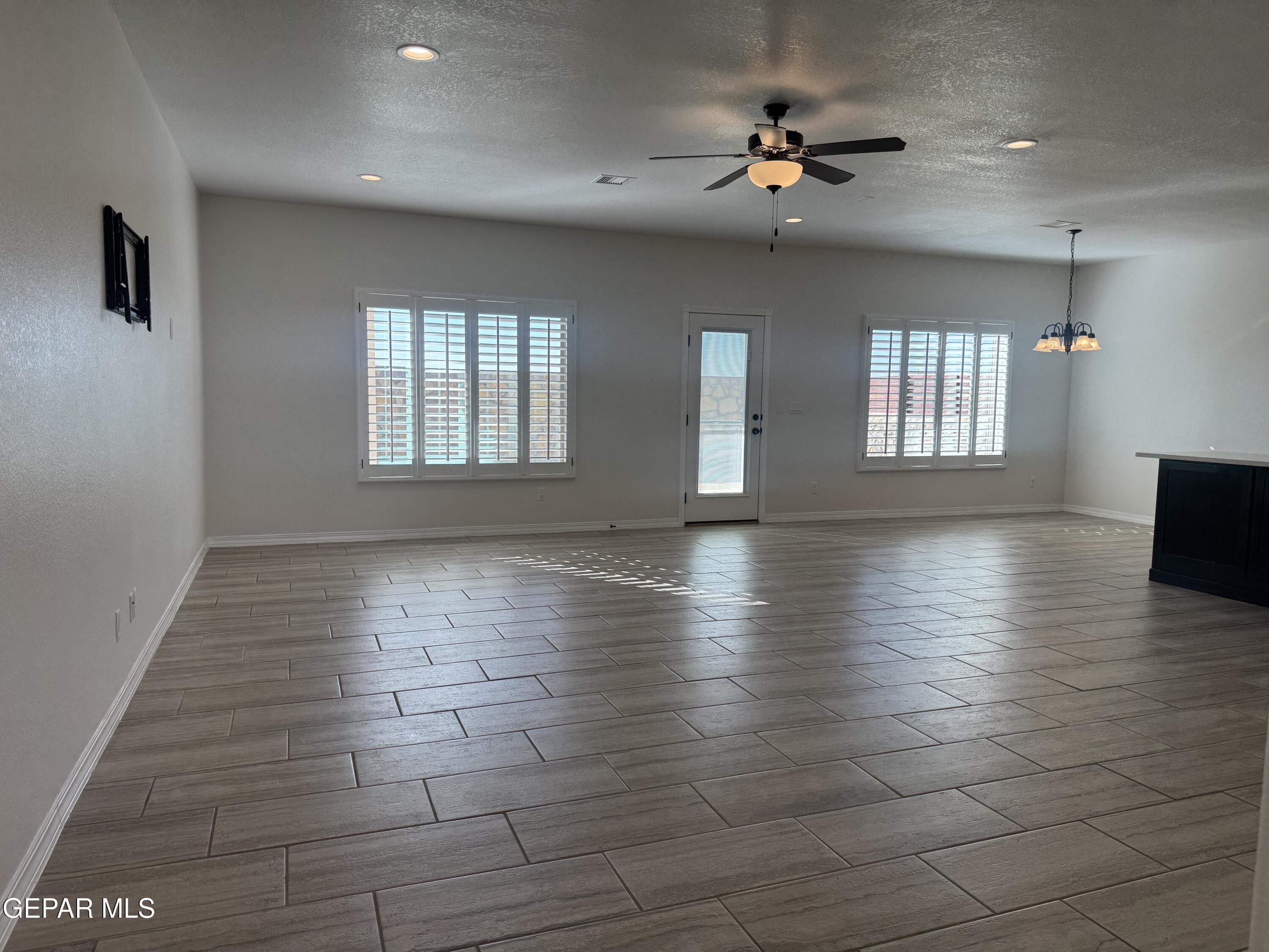 412 Indigo Court El Paso, TX 79932 - Photo 9 of 53 a view of an empty room with a window and wooden floor