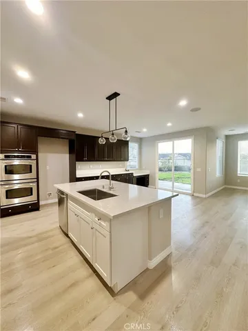 a kitchen with stainless steel appliances kitchen island a sink stove and cabinets