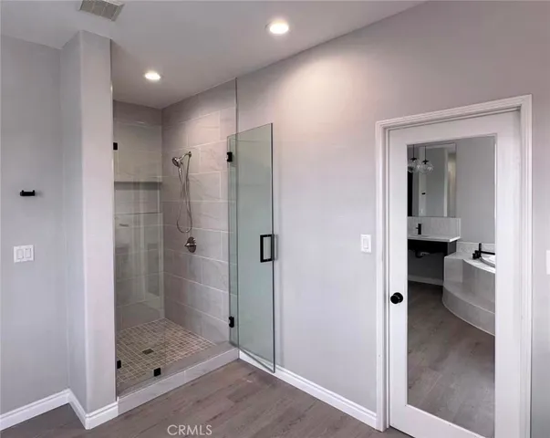 a bathroom with a glass shower door and a sink