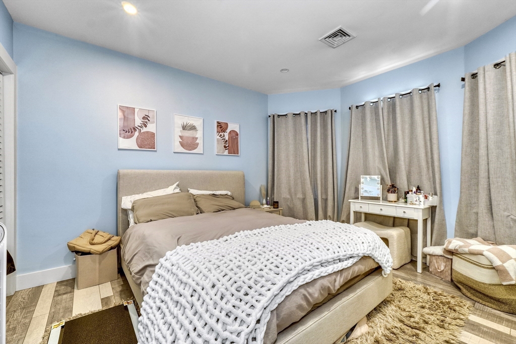 61 Shepton Street Boston, MA 02124 - Photo 12 of 38 a bedroom with a bed and a chandelier