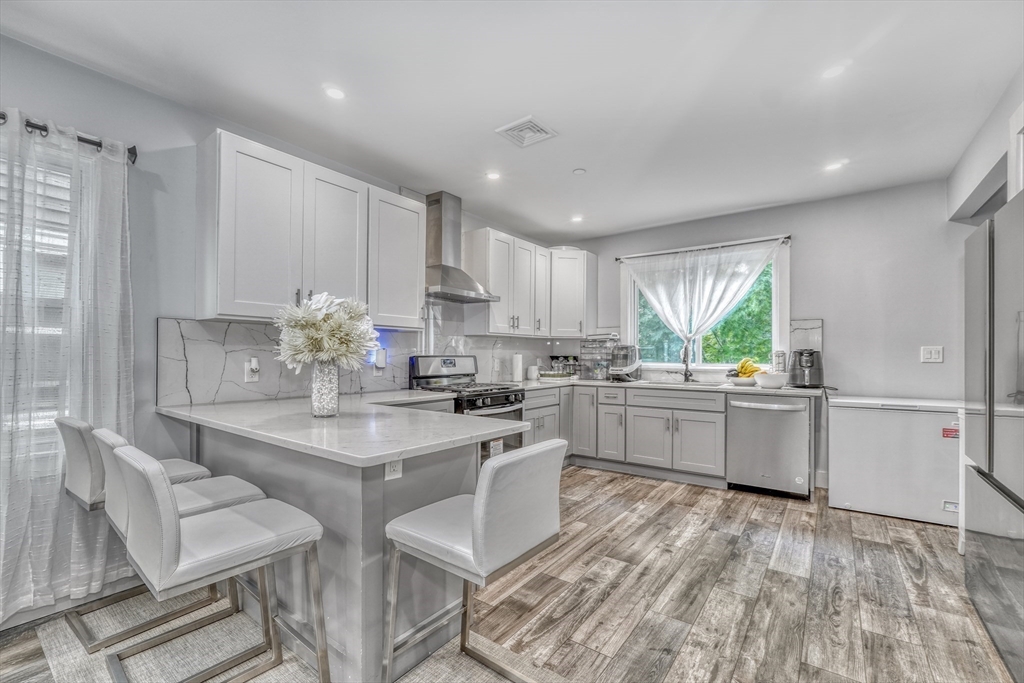 61 Shepton Street Boston, MA 02124 - Photo 16 of 38 a kitchen with granite countertop white cabinets and stainless steel appliances