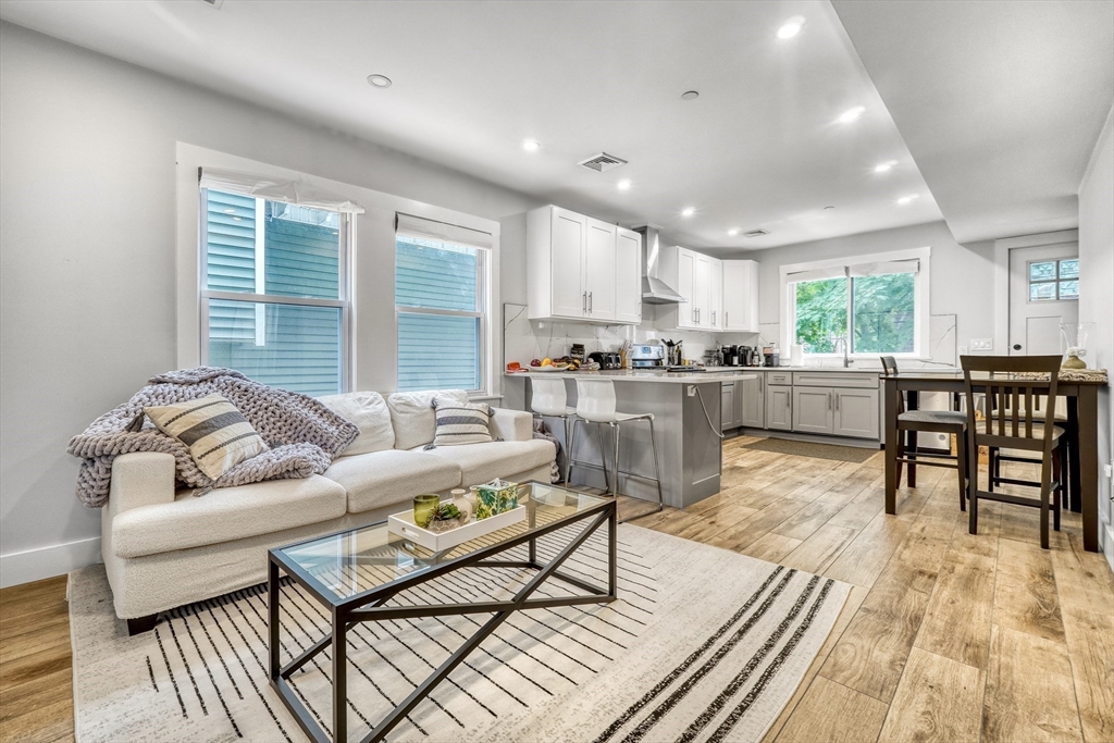 61 Shepton Street Boston, MA 02124 - Photo 2 of 38 a living room with stainless steel appliances granite countertop furniture a couch a table and kitchen view