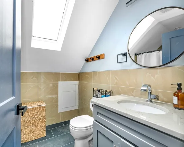 a bathroom with a granite countertop toilet sink and mirror